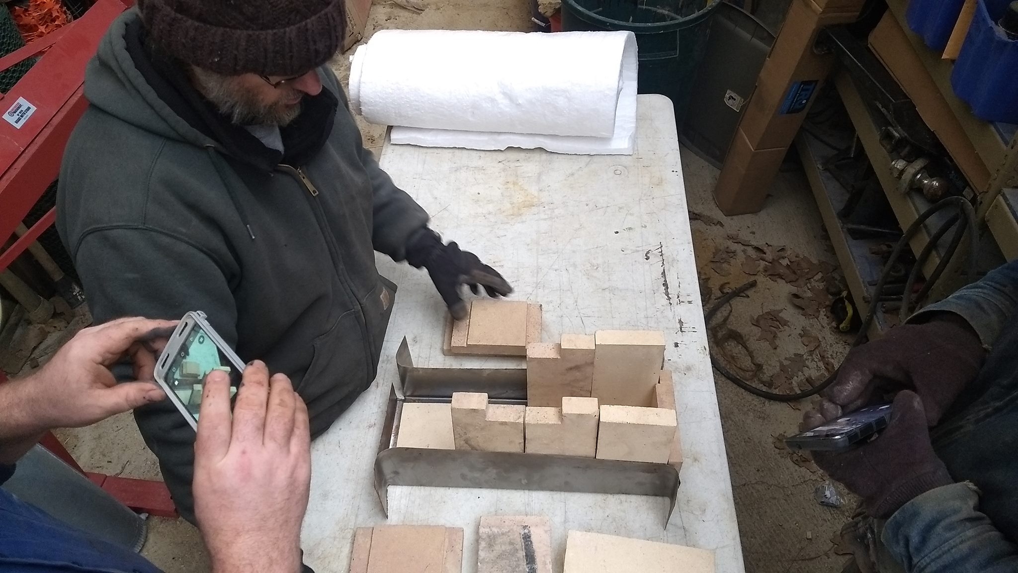 Taking a photo of someone taking a photo of positioning bricks for the burn chamber