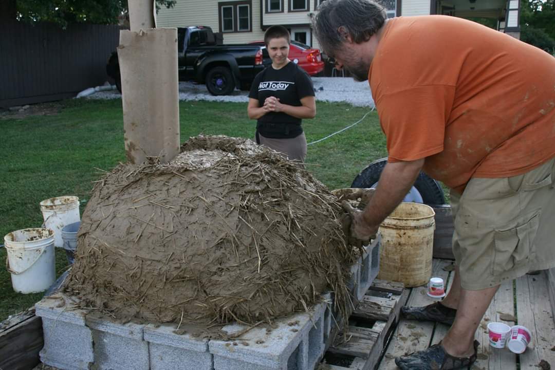 Covering the sand form with cob